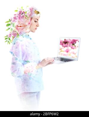 Doppelbelichtung der Frau mit Laptop und blühenden Baum. Natur- und Technologiekonzept. Stockfoto