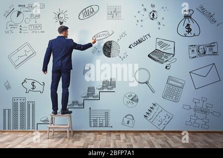 Geschäftsmann Zeichnung Plan auf blaue Wand. Business-Projekt Konzept. Stockfoto