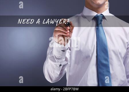 Geschäftsmann Hand Schreiben auf virtuellen Bildschirm. BRAUCHEN SIE EINEN ANWALT? Stockfoto