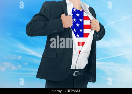 Geschäftsmann zeigt USA Flagge unter Anzug auf Himmel Hintergrund. Stockfoto