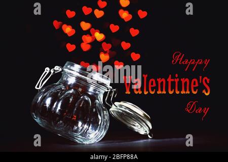 Herzen fliegen aus Glas. Unscharfer Hintergrund. Text glücklich Valentinstag. Stockfoto