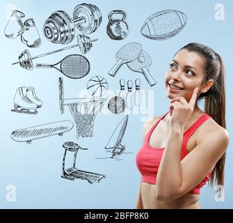 Sportliche junge Frau auf blauem Hintergrund. Sport Lifestyle Konzept. Vielfalt der Sport-Symbole auf Hintergrund. Stockfoto