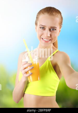 Schöne sportliche Frau, die Selfie auf verschwommenem Naturhintergrund nimmt. Sportkonzept. Stockfoto