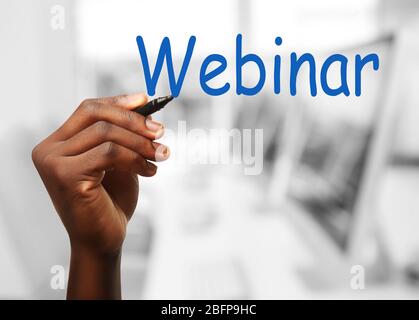 Webinar zum Schreiben von menschlichen Wörtern auf transparentem Whiteboard auf unscharfer Hintergrundfläche Stockfoto