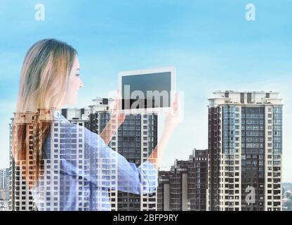 Konzept der virtuellen Technologien. Stadtbild und junge Frau mit Tablet Stockfoto
