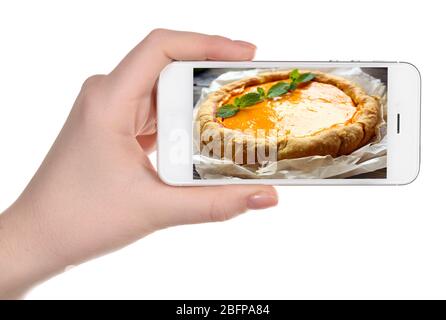 Weibliche Hand hält Smartphone auf weißem Hintergrund. Foto von Lebensmitteln auf dem Smartphone-Bildschirm. Stockfoto