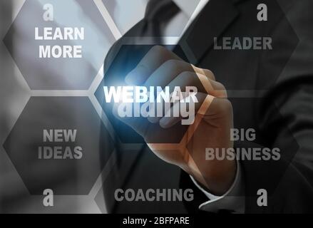 Geschäftsmann drückt WEBINAR-Taste auf dem virtuellen Bildschirm. Business Coaching und modernes Technologiekonzept. Stockfoto