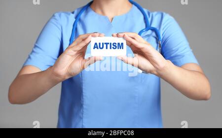 Kinder Autismus Konzept. Arzthände mit Karte auf grauem Hintergrund Stockfoto