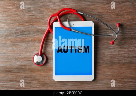 Kinder Autismus Konzept. Rotes Stethoskop und Tafel auf Holzhintergrund Stockfoto