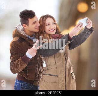 Junge glückliche Paar Selfie auf verschwommenem Hintergrund. Stockfoto