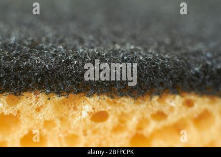 Abstrakter Hintergrund gelber Schwamm zum Spülen von Geschirr Nahaufnahme, selektiver Fokus Stockfoto