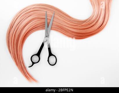 Erdbeer blonde Haare und Schere auf weißem Hintergrund Stockfoto