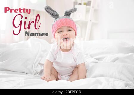 Konzept der Auswahl von Babynamen. Kleines Kind auf dem Bett sitzend Stockfoto