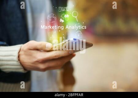 Marketing Analytics Konzept. Mann, der im Freien Smartphone verwendet Stockfoto