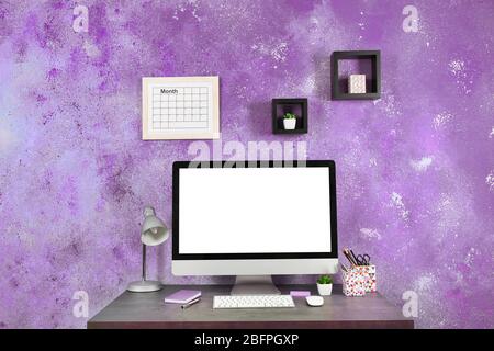 Lila Akzent in moderner Innenausstattung. Kreativer Arbeitsplatz mit Computer zu Hause Stockfoto