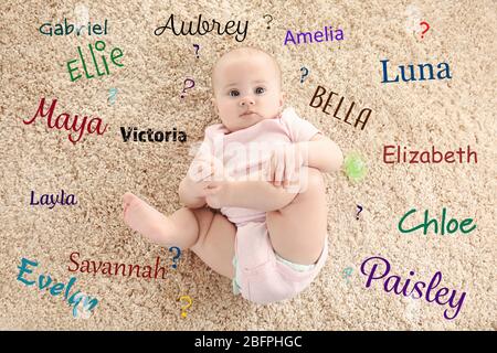 Konzept für Babynamen. Nettes kleines Mädchen auf dem Teppich liegend Stockfoto