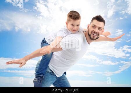 Vater und Sohn auf blauem Himmel Hintergrund. Konzept der Kindheit Stockfoto