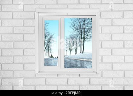 Blick auf die Winterstraße durch moderne Fenster im Zimmer Stockfoto