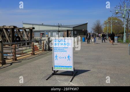 Schild Warnung Menschen zu sozialen Abstand halten 6 Fuß auseinander, Gruppen von Menschen, Hudson River Park, Manhattan, 4/19/20 Stockfoto