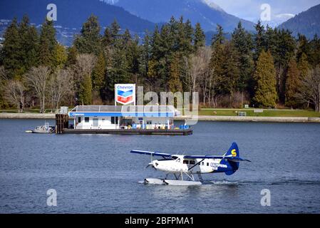 Vancouver, Kanada - 4. März 2020: Ein Salt Spring Air-Wasserflugzeug landet im Hafen von Vancouver. Im Hintergrund ist die Chevron Marine Fuel Barge. Stockfoto