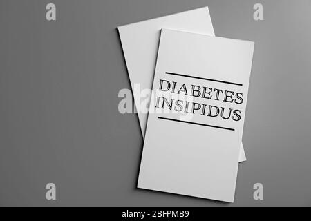 Konzept der Gesundheitsfürsorge. Broschüre mit Titel DIABETES INSIPIDUS auf grauem Hintergrund Stockfoto