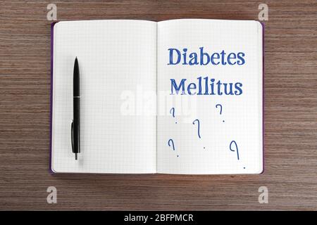 Konzept der Gesundheitsfürsorge. Notizbuch mit Text DIABETES MELLITUS und Stift auf Holzhintergrund Stockfoto