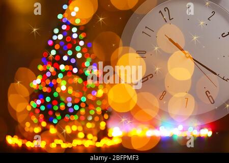 Countdown bis zur Feiertagsfeier. Uhr und verwischter Weihnachtsbaum auf Hintergrund Stockfoto