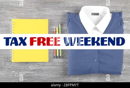 Text STEUERFREI WOCHENENDE und Schulbedarf mit Uniform auf Holzhintergrund Stockfoto