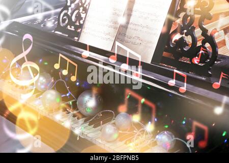 Klavier mit schönen Dekorationen, Nahaufnahme. Konzept der Weihnachtsmusik und Lieder Stockfoto