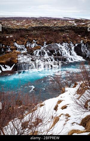 Hraunfossar Wasserfälle, die im Winter in den von Gletschern gespeisten Hvita Fluss in Island stürzen Stockfoto