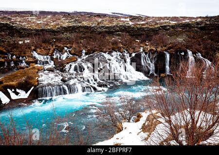 Hraunfossar Wasserfälle, die im Winter in den von Gletschern gespeisten Hvita Fluss in Island stürzen Stockfoto