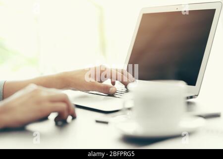 Mann, der Laptop zum Surfen im Internet-Shop am Tisch, Nahaufnahme. Online-Shopping-Konzept Stockfoto