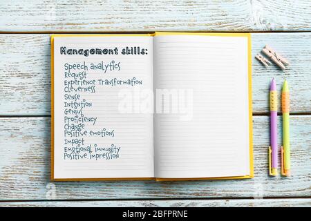 Liste der MANAGEMENT-FÄHIGKEITEN in Notizbuch auf Holzhintergrund geschrieben Stockfoto
