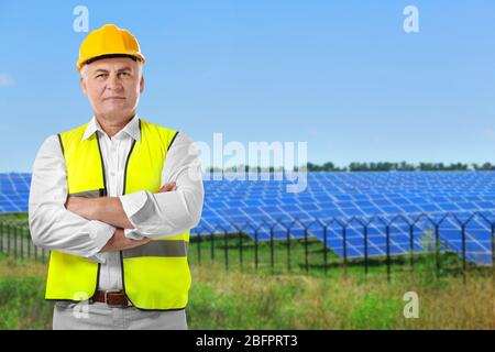 Leitender Ingenieur und Solarmodule im Hintergrund Stockfoto