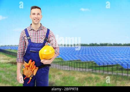 Junger Ingenieur und Solarpaneele auf Hintergrund Stockfoto