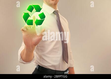 Mann zeigt Zeichen des Recyclings auf dem virtuellen Bildschirm. Ökologie und Umweltschutz Stockfoto