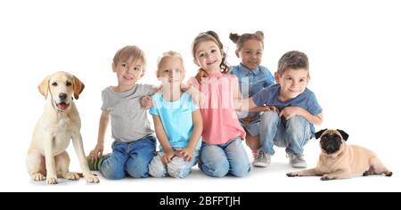 Kleine Kinder mit niedlichen Hunden auf weißem Hintergrund Stockfoto