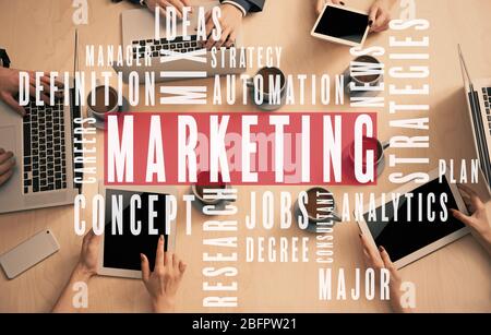 MARKETING Wort Cloud und Menschen mit Computern im Hintergrund Stockfoto