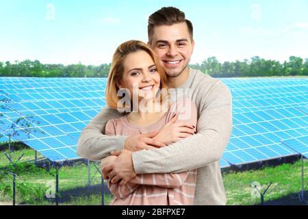 Junges Paar und Sonnenkollektoren auf Hintergrund Stockfoto