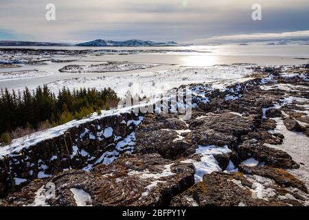 Blick über den Thingvellir (Þingvellir) Nationalpark auf der tektonischen Plattengrenze des Mittelatlantischen Rückens im Südwesten Islands im Winter im Schnee Stockfoto