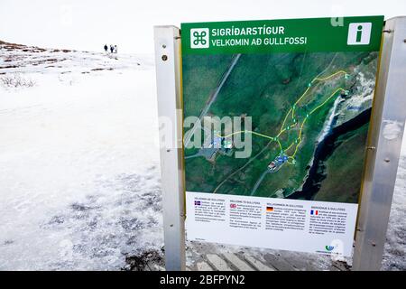 Im Winter lädt ein Schild die Besucher zum gefrorenen Wasserfall in Gullfoss, Golden Circle, Island im Schnee ein Stockfoto