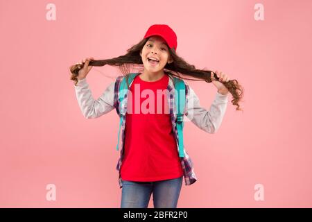 Ihr eigener Friseur. Happy girl halten lange Haare rosa Hintergrund. Kinderfriseur. Friseursalon für Kinder. Schönheitssalon. Friseursalon mit Friseursalon. Gönnen Sie sich einen großartigen Service. Stockfoto