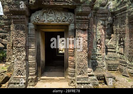 Schnitzereien von Dämonen und Apsara-Tänzern aus der Hindu-Mythologie an einem Türrahmen im Preah Khan 'Tomb Raider'-Tempel in Angkor Wat, Siem Reap, Kambodscha Stockfoto