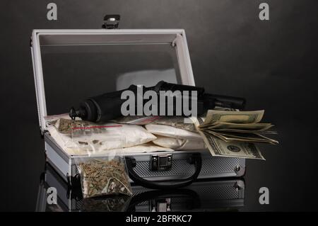 Kokain und Marihuana mit Pistole in einem Koffer auf grauem Hintergrund Stockfoto