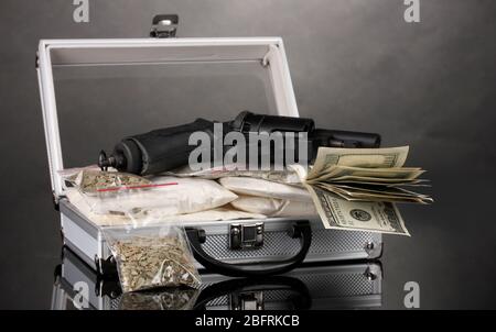 Kokain und Marihuana mit Pistole in einem Koffer auf grauem Hintergrund Stockfoto