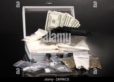 Kokain und Marihuana mit Pistole in einem Koffer auf grauem Hintergrund Stockfoto