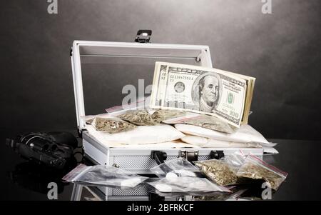 Kokain und Marihuana mit Pistole in einem Koffer auf grauem Hintergrund Stockfoto