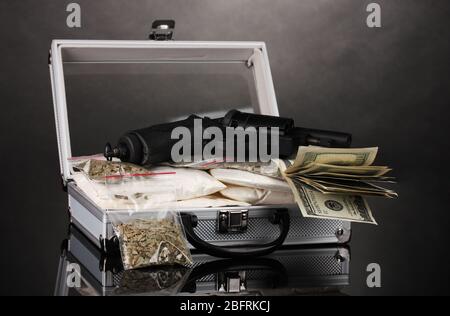 Kokain und Marihuana mit Pistole in einem Koffer auf grauem Hintergrund Stockfoto