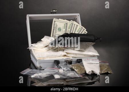 Сocaine und Marihuana mit Pistole in einem Koffer auf grauem Hintergrund Stockfoto
