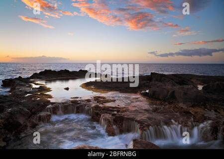 Sonnenuntergang über den zahlreichen Lavaröhren, die durch die Flut im Kohanaiki Beaach Park entlang der Kona Küste auf der Big Island von Hawaii aufgefüllt wurden. Stockfoto